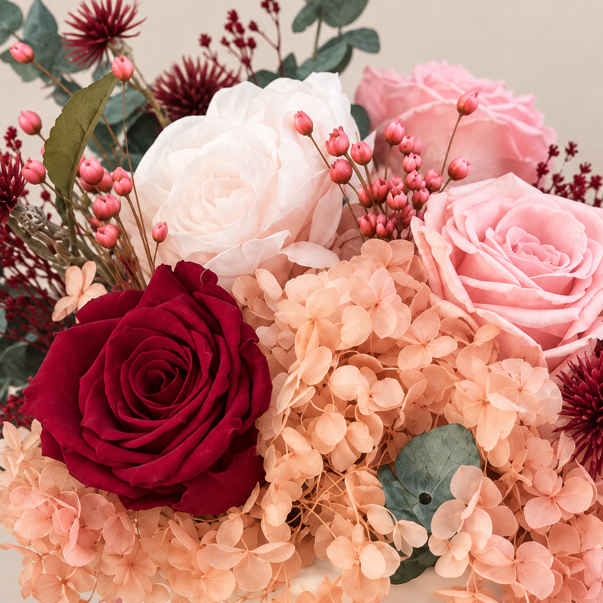 Dettaglio di Sussurro di Cipria: rosa bordeaux, rose rosa e avorio, ortensie cipria e bacche stabilizzate.
